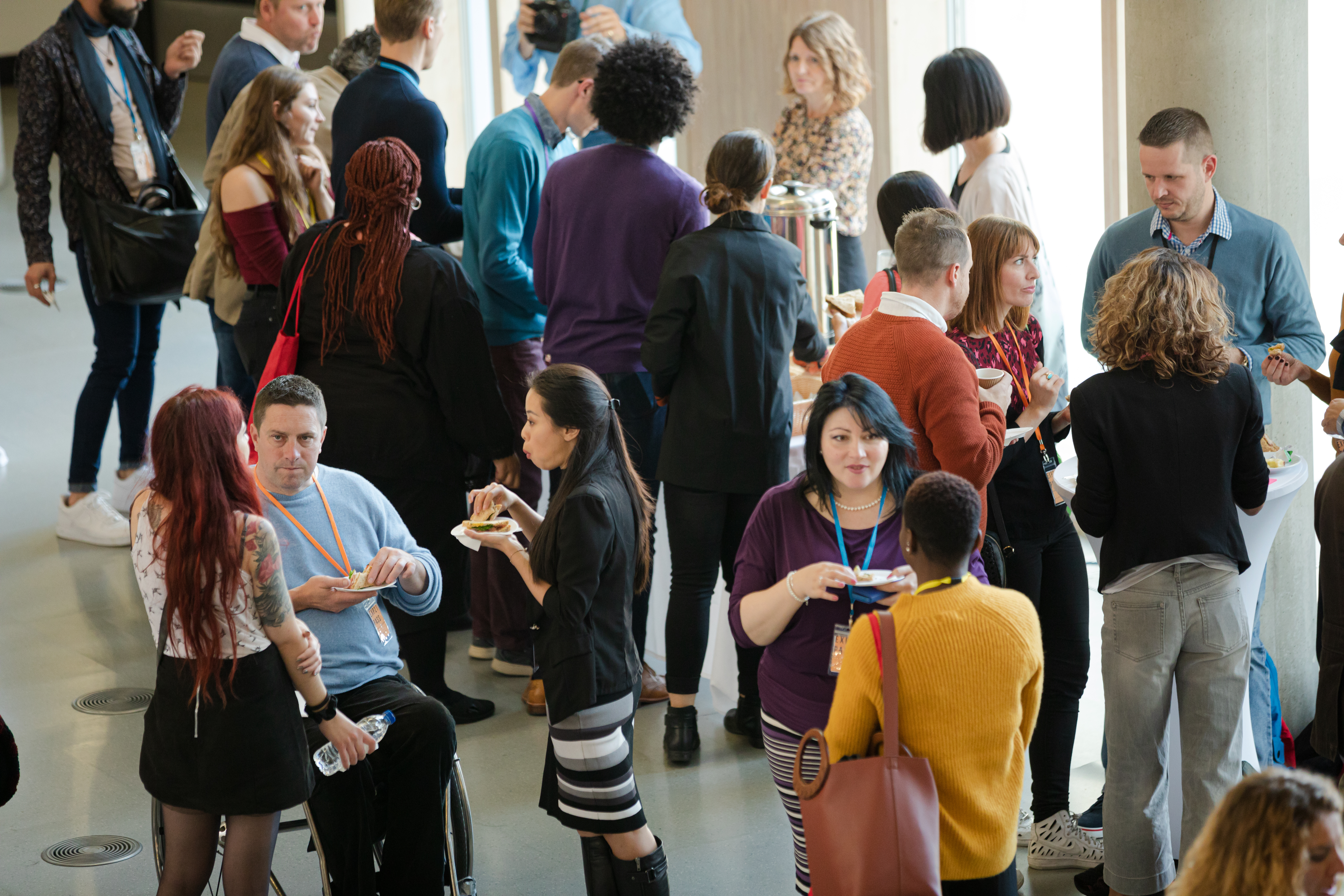 Attendees in a large hallway chatting during a conference