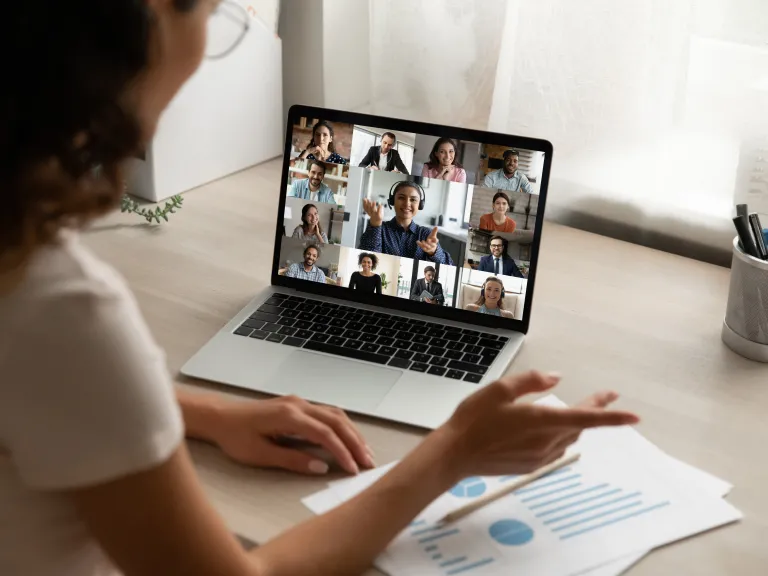 Back view of female employee on video call with colleagues.