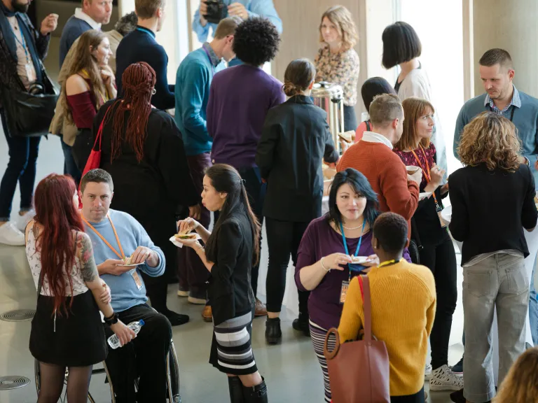 Attendees in a large hallway chatting during a conference