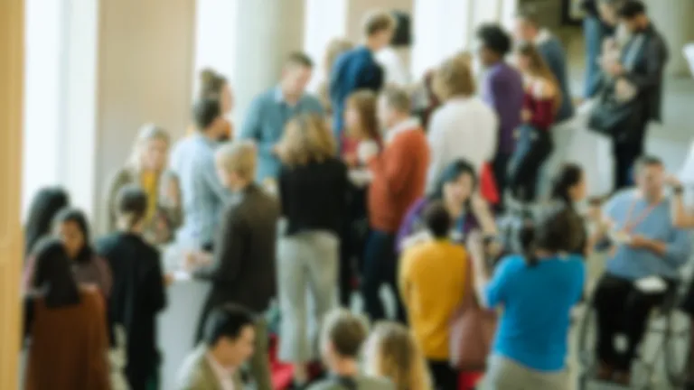 Large group of people chatting with each other in spacious event hall