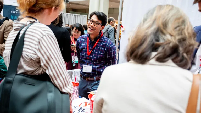 Exhibitor greeting person at their booth