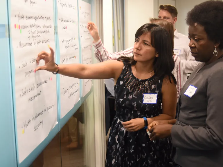 Two people contemplating a flipboard sheet with notes